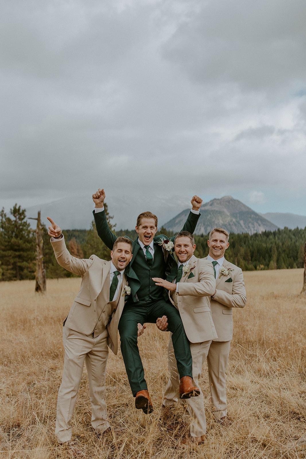 a bridal party wears tan groomsmen suits and celebrates at a mountain wedding in california 