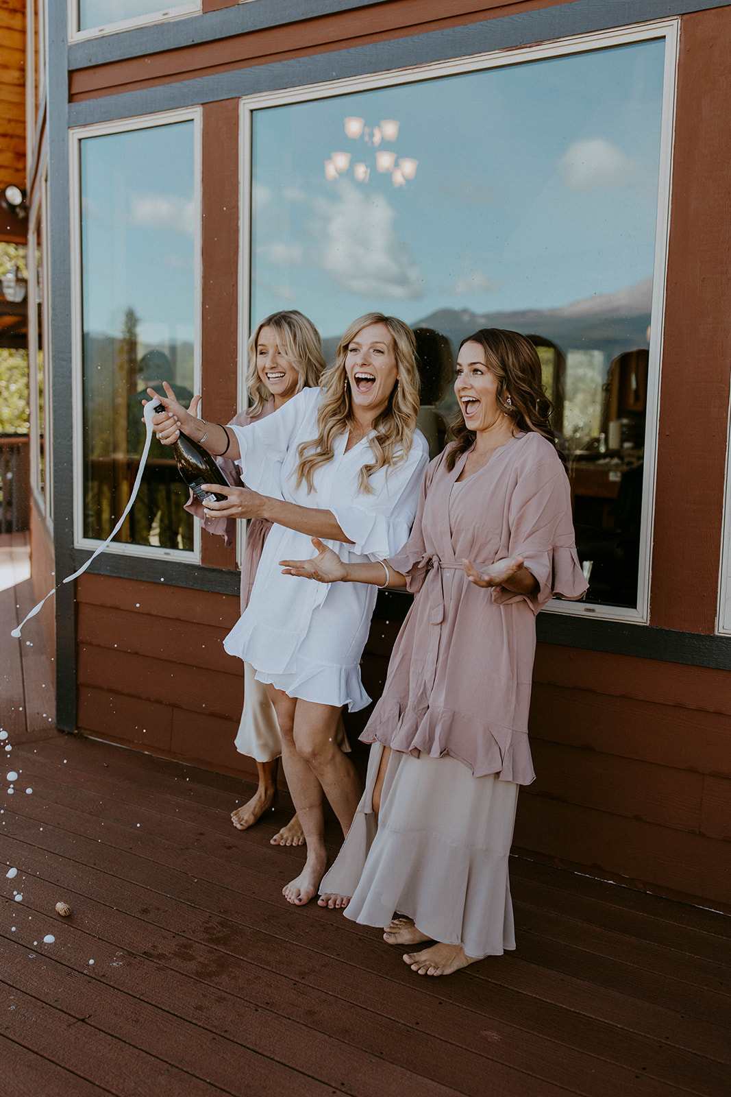bride and her bridesmaids pop champagne at an intimate fall wedding in northern california