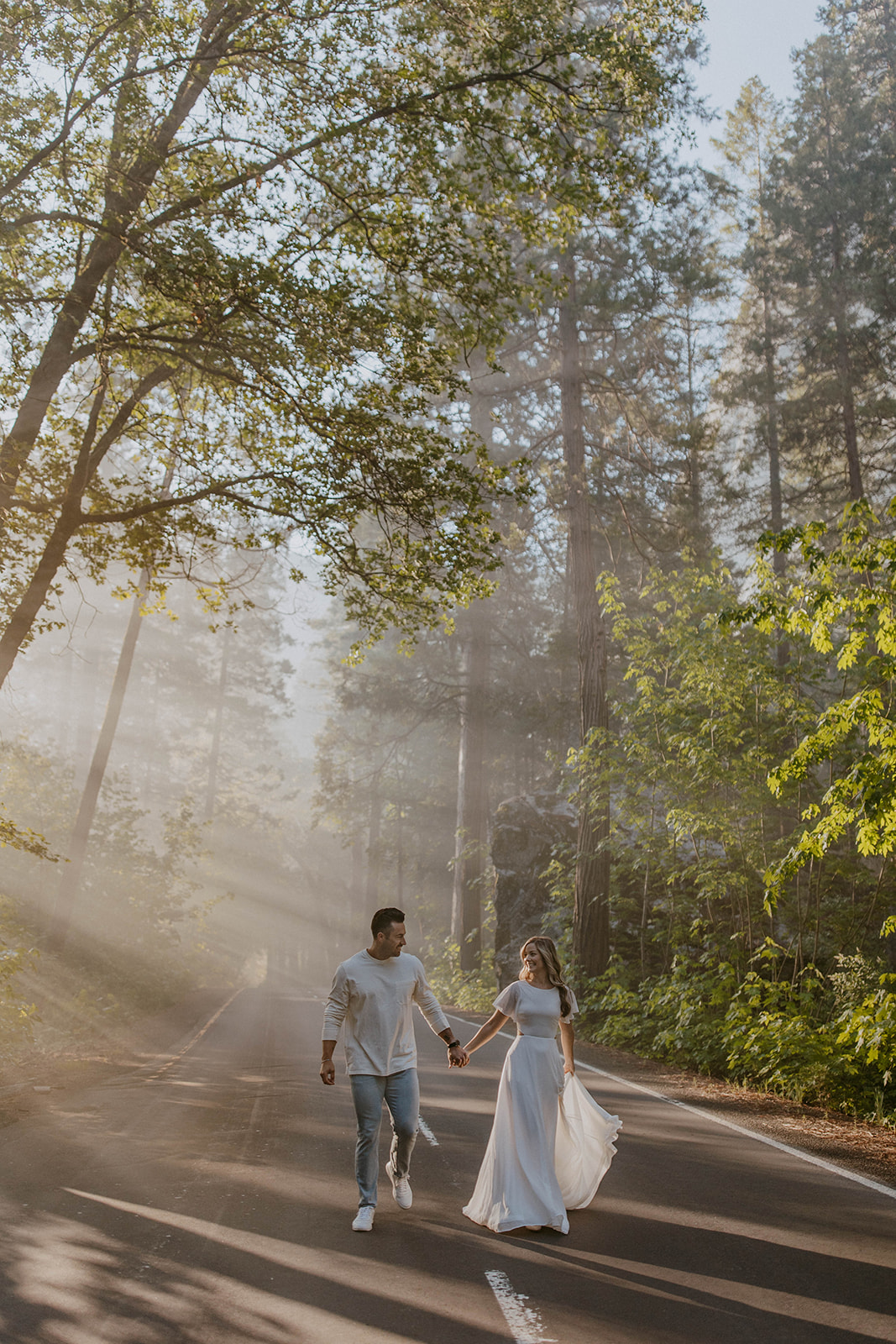 couple walking down road during fall engagement photoshoot in yosemite national park 